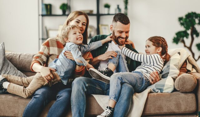 A happy family laughing together on a couch